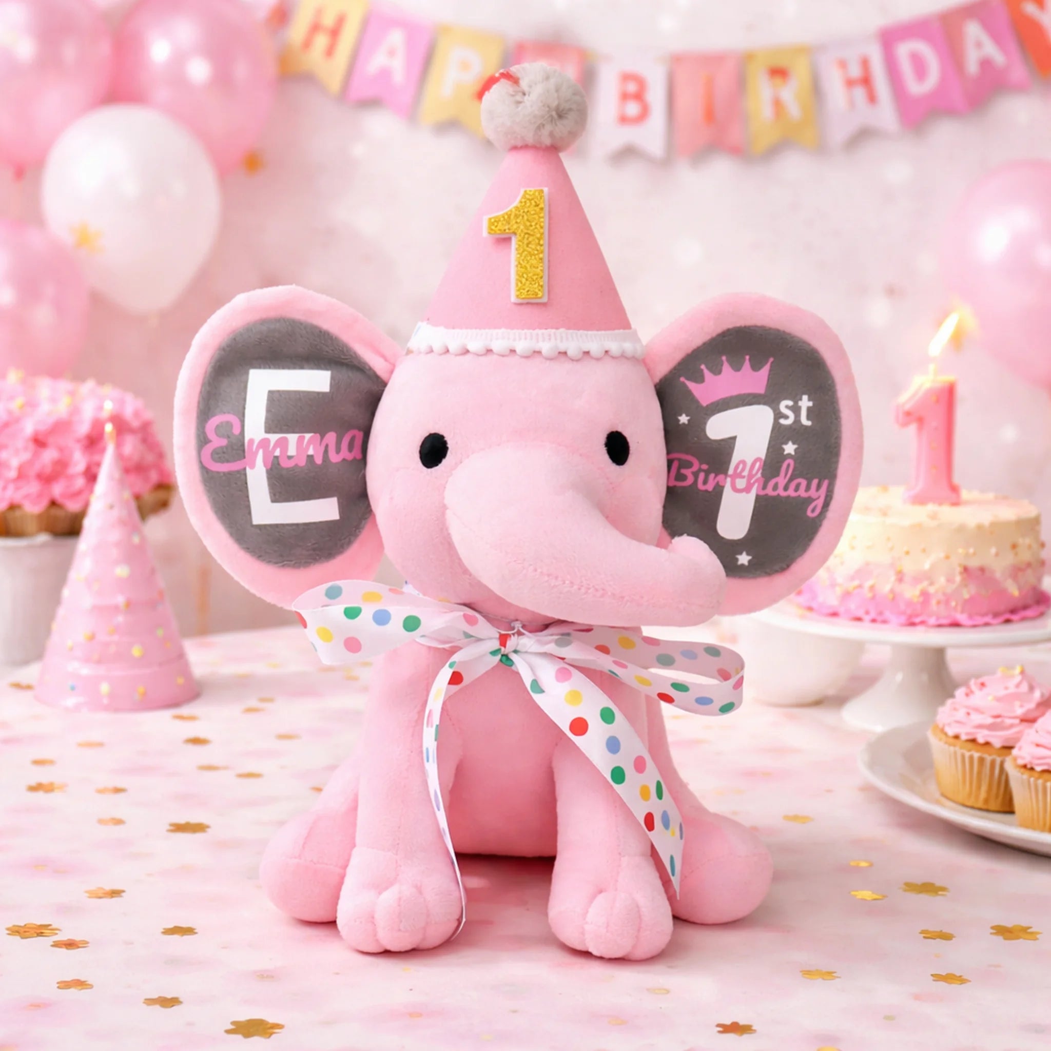 Pink personalized first birthday elephant plush with party hat, bow, and name Emma on the ear.