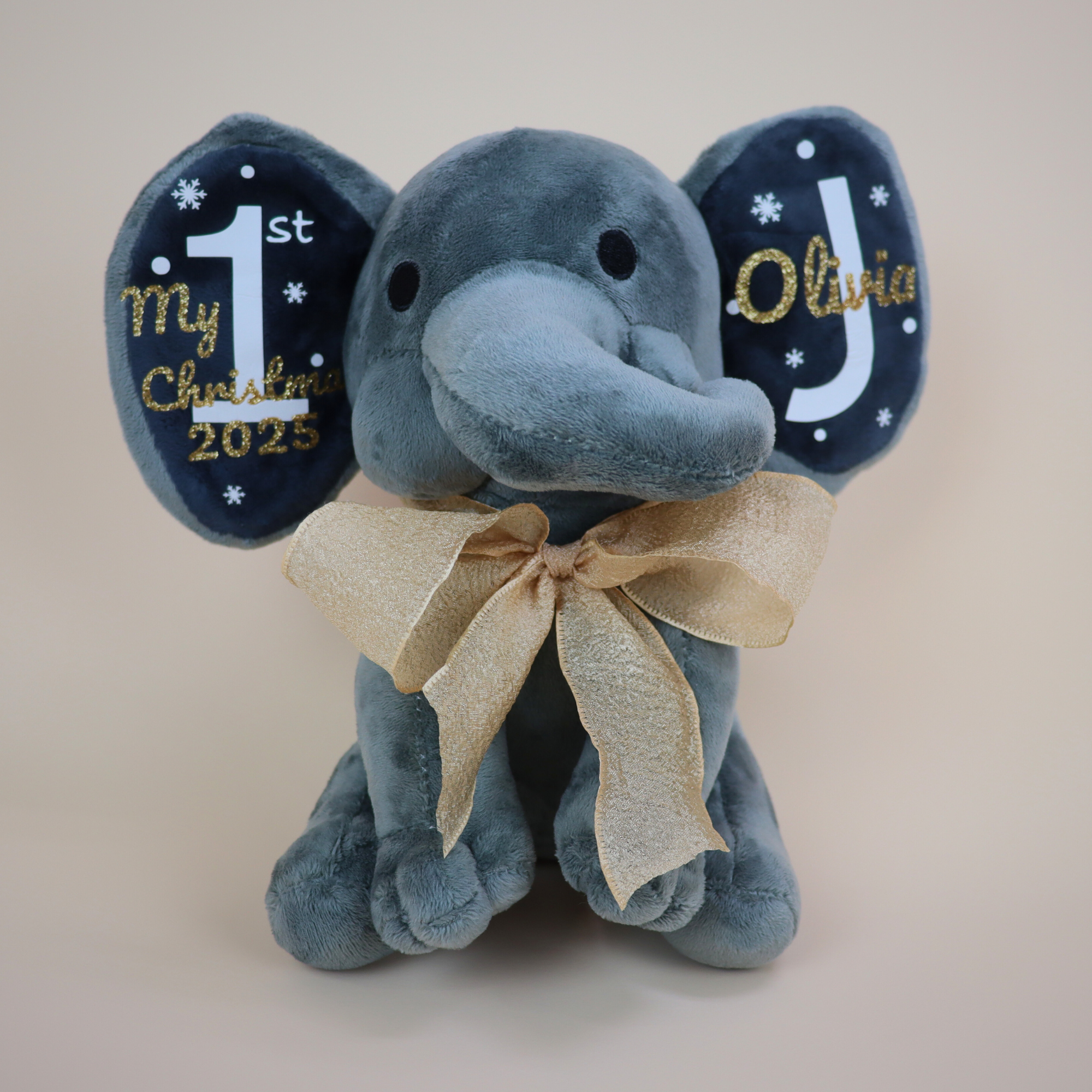 Close-up of personalized embroidery on elephant ear with 'My 1st Christmas' text.